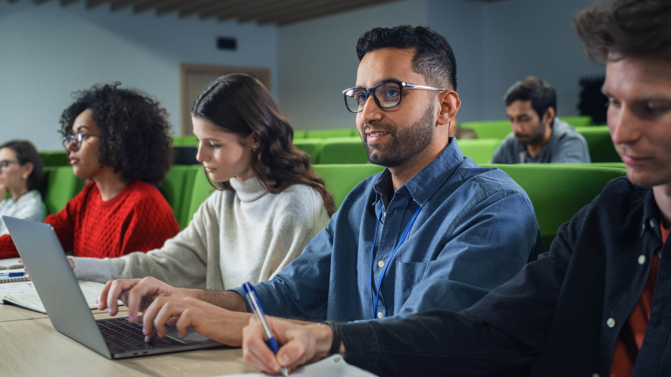 Student in class watching the teaching surrounded by classmates