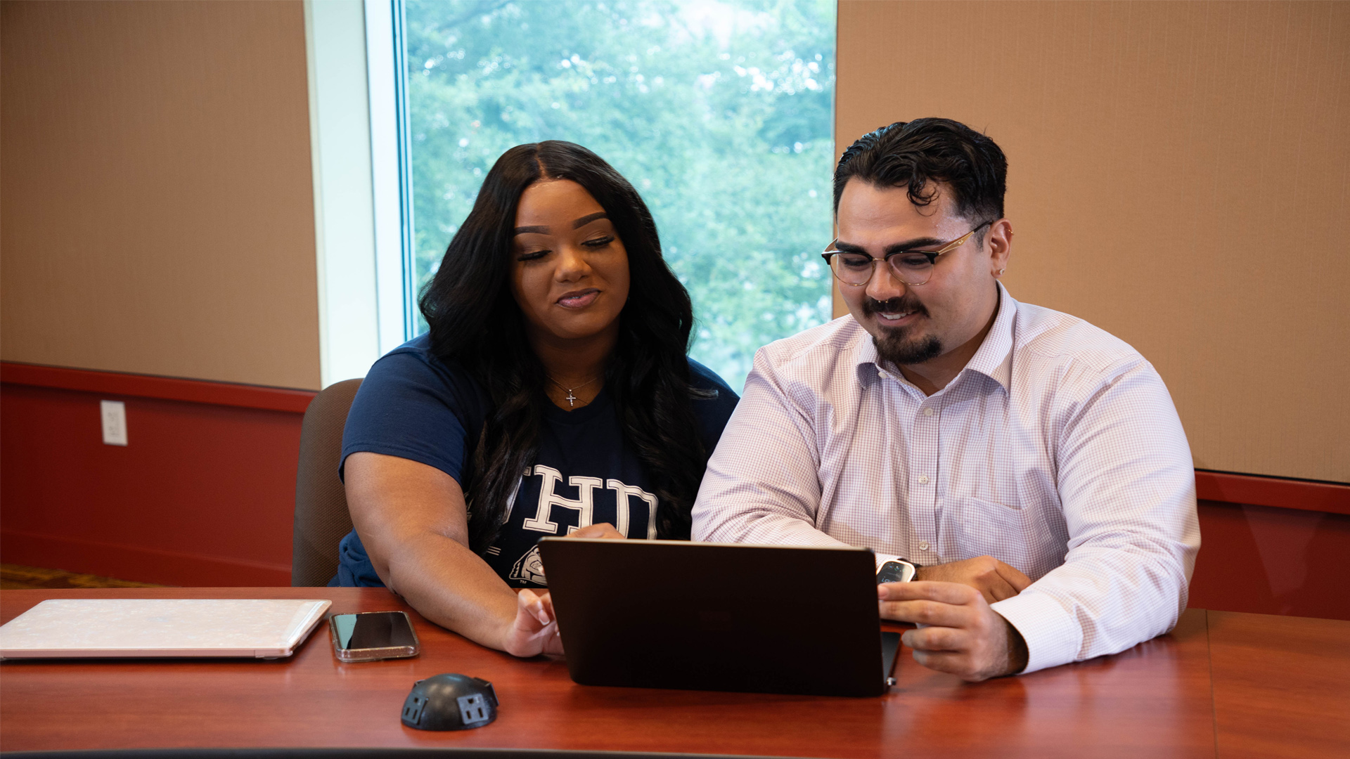 Two students researching on the same laptop