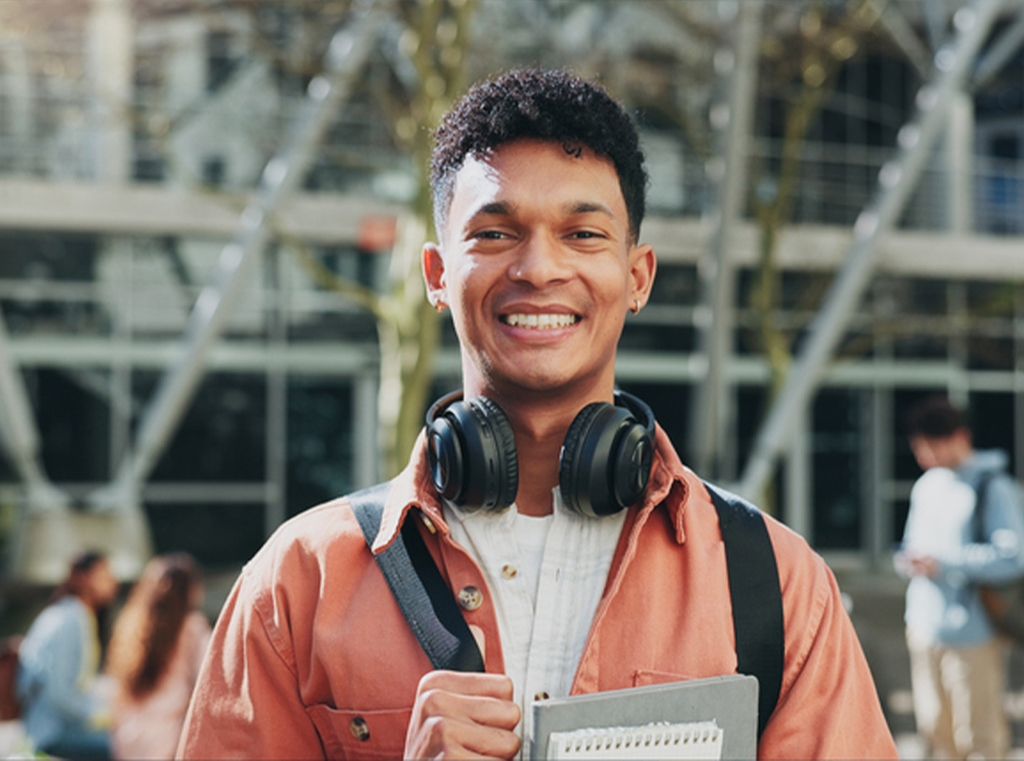 Student with headphones smiling.
