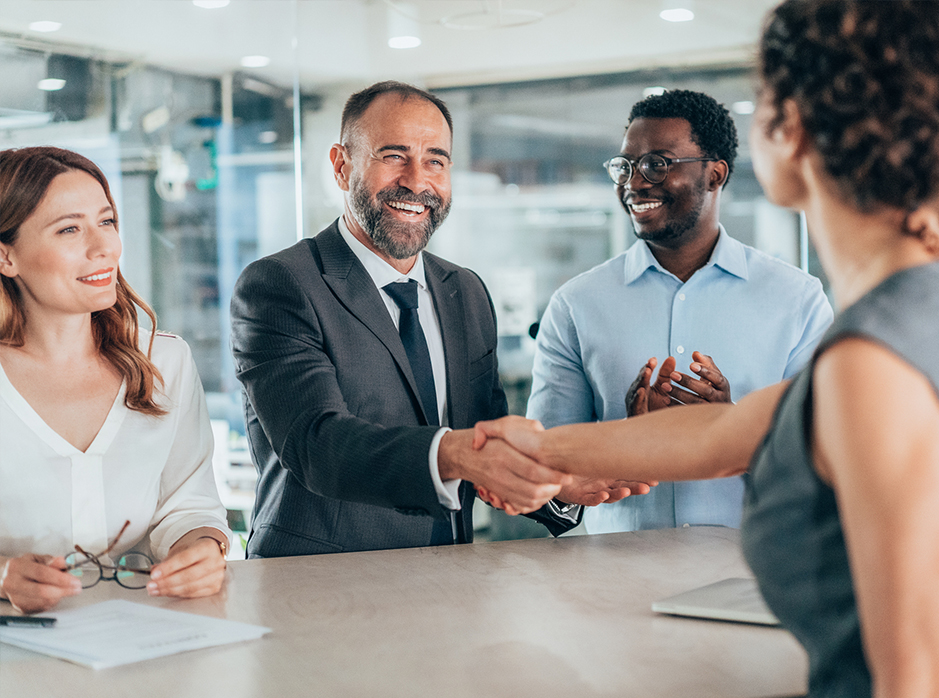 Coworkers shaking hands and smiling.