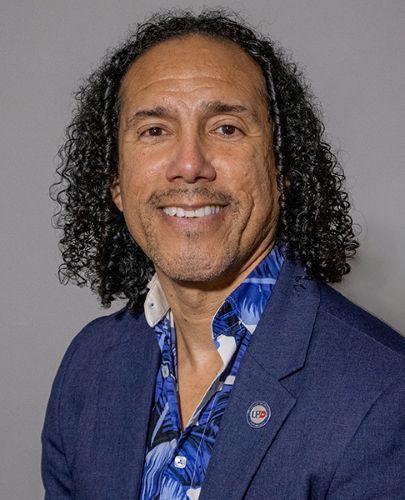 Dean José Ricardo-Osorio ​in a flower-print shirt and blue jacket.