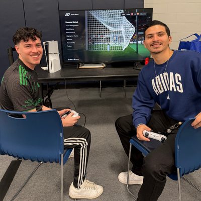 Two university of houston-downtown students play a video game at the esports competition at gatorcon