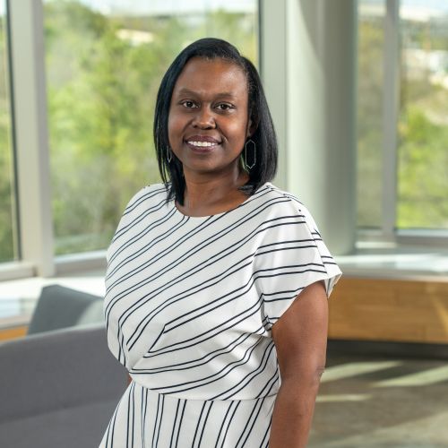 Shiya Rawls headshot, wearing a white and black striped shirt.