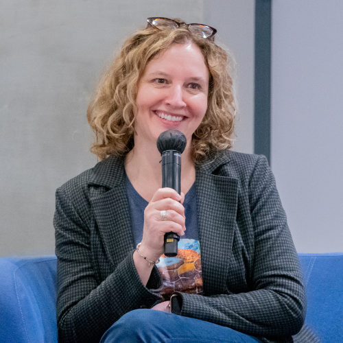 Katharine Owens holds a microphone in her hands while speaking at the president's lecture series at uhd's college of sciences and technology