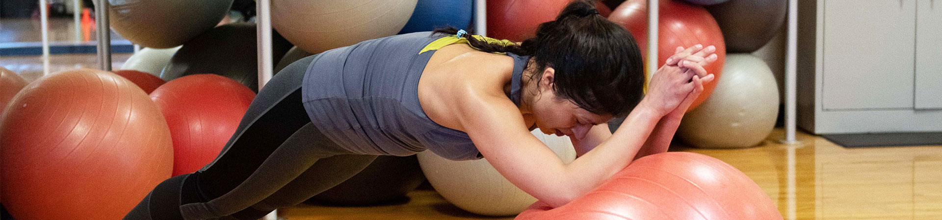 woman engaging in core strenghting exciercise with an excercise ball