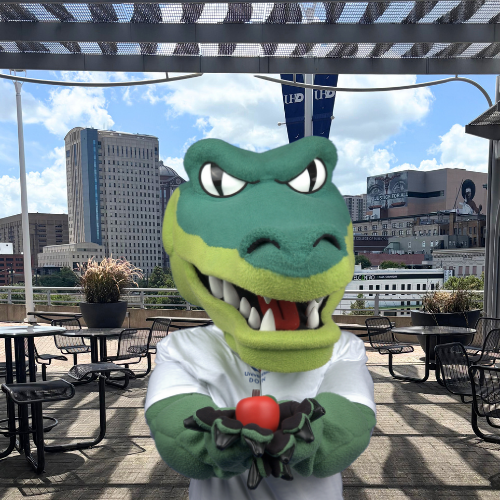 Ed-U-Gator UHD's gator mascot holds a red apple on the south deck at the university of houston downtown in downtown houston