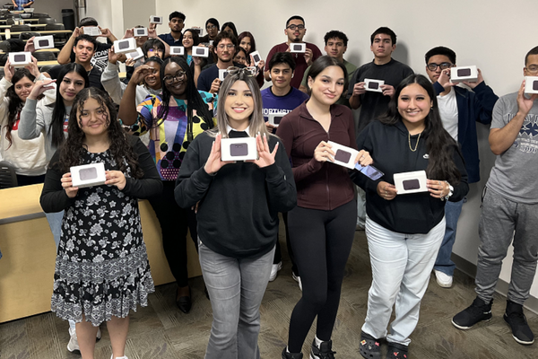 Students in university of houston downtown's summer bridge program hold up free wifi hotspots provided by tmobile