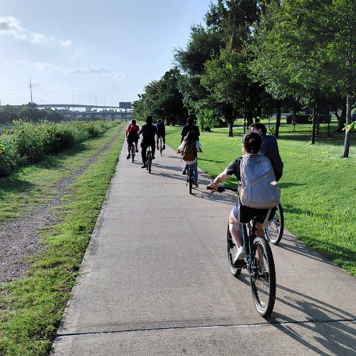 students in university of houston downtown's bke club ride on a trail aside the bayou
