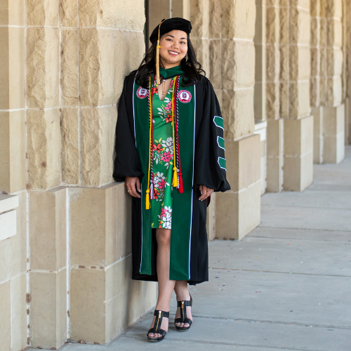Boranai Tychhon smiles while wearing graduation regalia