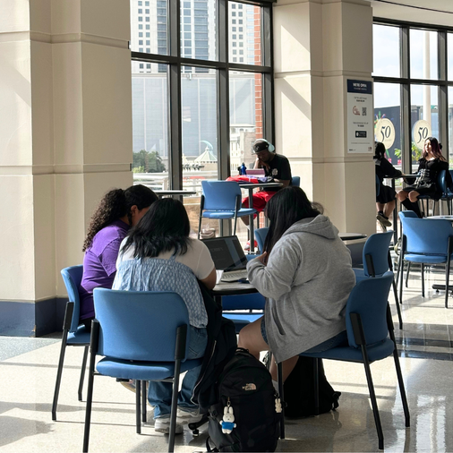 Students sit at tables with laptops in the University of Houston Downtown's Skyline Lounge