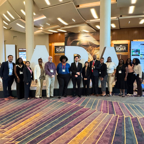 Students in University of Houston Downtown NABA chapter alongside a faculty advisor smile at the 54th annual NABA Convention and Expo in Las Vegas