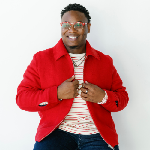Brandon Jenkins a University of Houston Downtown alum smiles while wearing a red jacket 