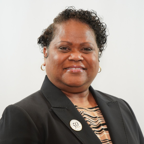 Rebecca Hamilton smiles while wearing a blazer and a University of Houston Downtown 50th anniversary pin