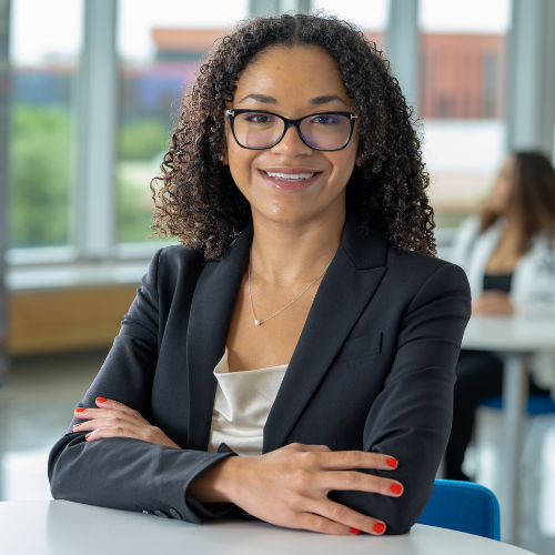 Felicity tutu smiles while sitting in the university of houston downtown's welcome center. Tutu is a university of houston downtown alumni from the university's Strategic Communications graduate program.