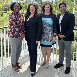 Key leaders of the lions to gators future teacher alliance Tonya Jeffery, Deborah Bronner-Westerduin, Barbi Seals, and Ash Tiwari smile on a balcony in Houston, Texas. 